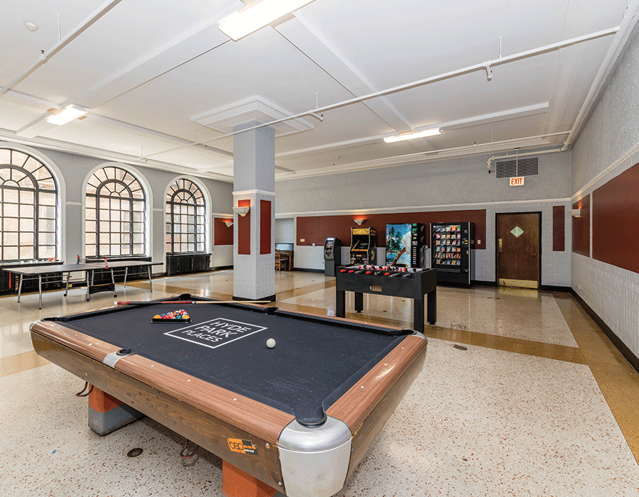 Large game and lounge room with pool table and vending machines on ground level of Hyde Park apartment building 