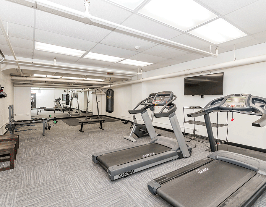 Fitness room with treadmills and bag equipment available at Hyde Park apartment building 